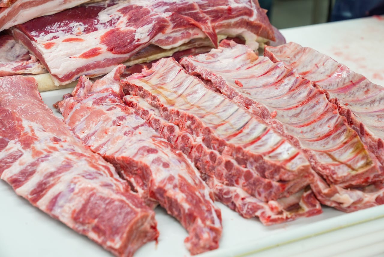 award-img Close-up of fresh raw pork ribs neatly arranged on a cutting board, showcasing marbling.